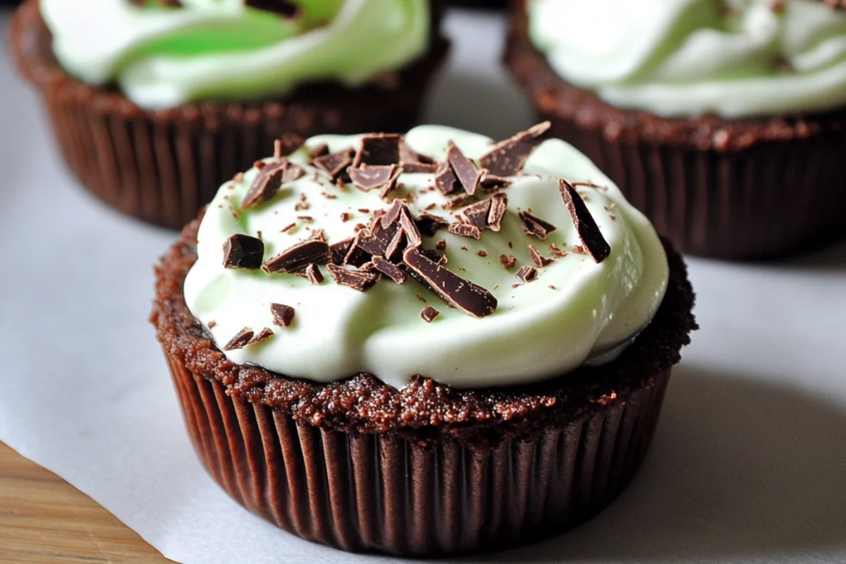 Front view of mini grasshopper pies with a chocolate cookie crust and mint cream filling, topped with a drizzle of dark chocolate, served in glass ramekins on a sleek modern surface with soft natural lighting
